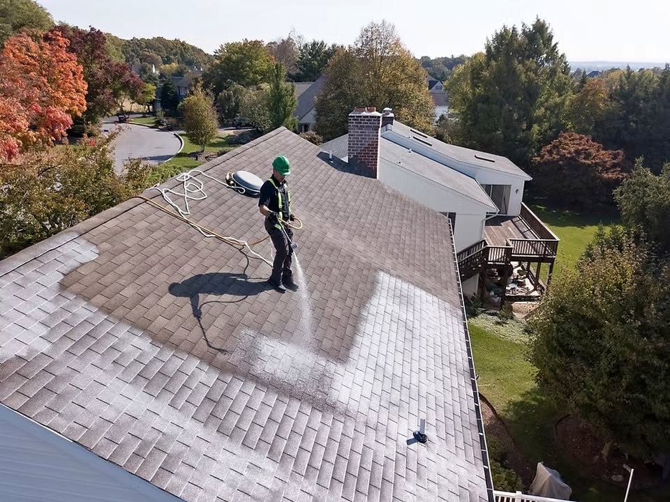A technician spraying roof rejuvenation treatment